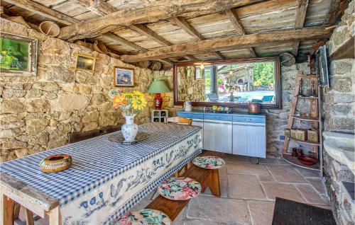 a kitchen with a table with a vase of flowers on it at Cozy Home In Augignac in Augignac