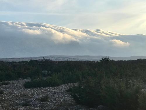 a view of a mountain with clouds in the sky at Guesthouse - Hotel California in Novalja