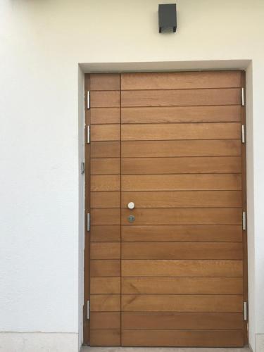 drewniane drzwi garażowe w białej ścianie w obiekcie Guesthouse - Hotel California w Novalji