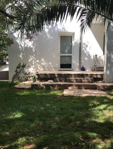 a house with a porch and stairs in the grass at Guesthouse - Hotel California in Novalja