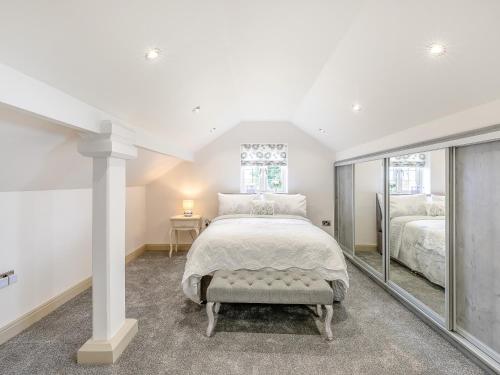 a white bedroom with a large bed and a window at Goosehill Fold in Normanton