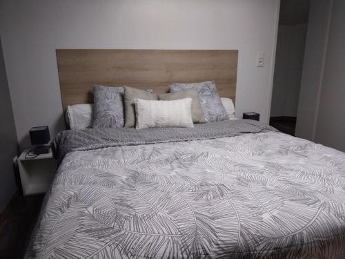 a bedroom with a large bed with a wooden headboard at Charmant appartement au cœur de ville de Toul in Toul