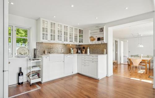 a kitchen with white cabinets and a wooden floor at 2 Bedroom Awesome Home In Haarby in Hårby