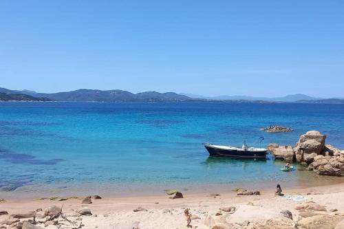 una barca in acqua su una spiaggia di Sleep in the bay on my boat a Porto San Paolo