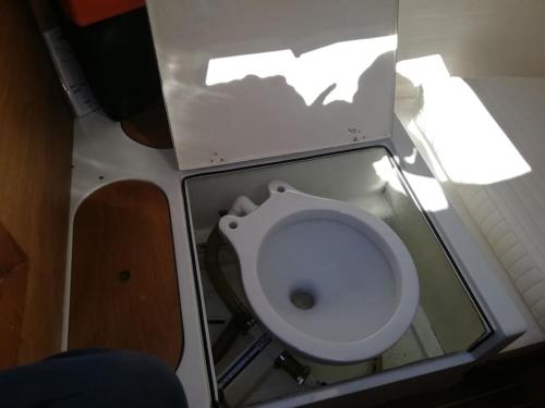 La salle de bains est pourvue de toilettes blanches. dans l'établissement Sleep in the bay on my boat, à Porto San Paolo