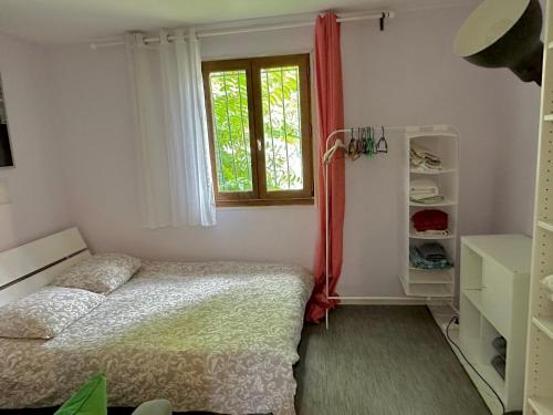 une petite chambre avec un lit et une fenêtre dans l'établissement Aubervilliers maison de ville près métro 7 by immo kit bnb, à Aubervilliers