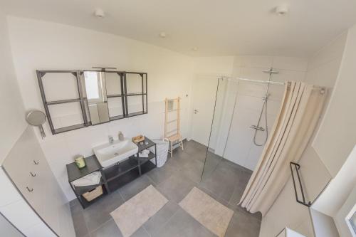 - une vue de tête sur une salle de bains pourvue d'une douche et d'un lavabo dans l'établissement Luxus Apartment Bad Salzuflen, à Bad Salzuflen