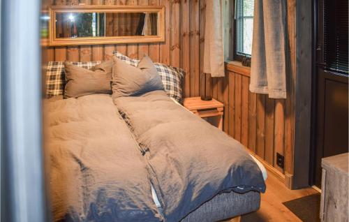 Bett in einem Zimmer mit holzgetäfelten Wänden in der Unterkunft 3 Bedroom Beautiful Home In Rauland in Rauland
