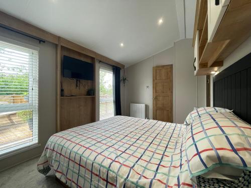 - une chambre avec un lit et une grande fenêtre dans l'établissement 16 Lake View, Pendle View Holiday Park, Clitheroe, à Clitheroe