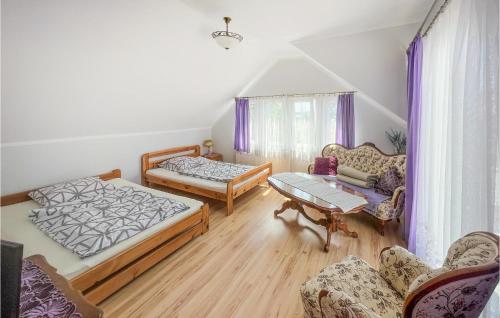 een woonkamer met 2 bedden en een tafel bij Amazing Apartment In Uniescie With Lake View in Unieście