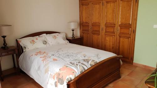 - une chambre avec un lit et une armoire en bois dans l'établissement Rez de jardin, à Vescovato