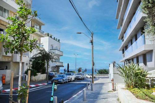 a street with cars parked on the side of a building at Relax Sea View 3BR in Gordon Beach by Holyguest in Tel Aviv