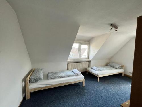a attic room with two beds and a window at Ferienwohnung / Monteurzimmer in Kitzingen