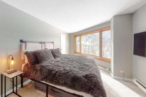 sypialnia z dużym łóżkiem i oknem w obiekcie Renovated Condo In West Keystone With Balcony, Hot Tub, Pool & Free Shuttle To Slopes! w mieście Keystone