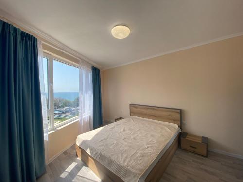 ein Schlafzimmer mit einem Bett und einem großen Fenster in der Unterkunft MARINA BAY 23 Sveti Vlas Beach in Sweti Wlas