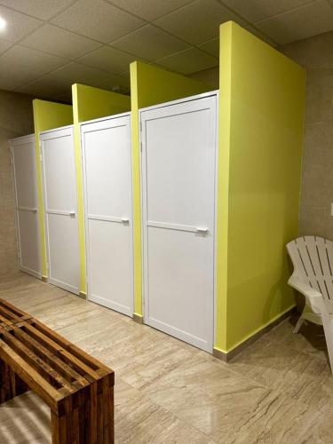 an empty room with three lockers and a bench at Hostel Tropico 20 PDC in Playa del Carmen
