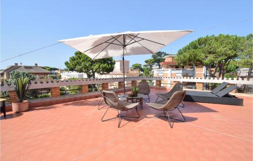 a patio with two chairs and a table with an umbrella at Stunning Home In Anzio With Kitchen in Anzio