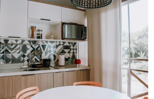 a kitchen with a table with chairs and a television at Ubaia charme & conforto in Pipa