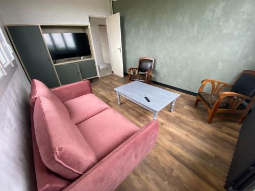 - un salon avec un canapé rose et une table dans l'établissement Chambre dans maison à partager, à Talensac