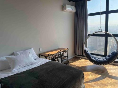 a bedroom with a bed and a hanging chair at Sky Loft - Andar 41 in Sao Paulo