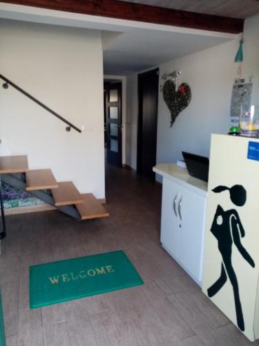 a kitchen with a welcome mat on the floor at Albergue Oasis in Sarria
