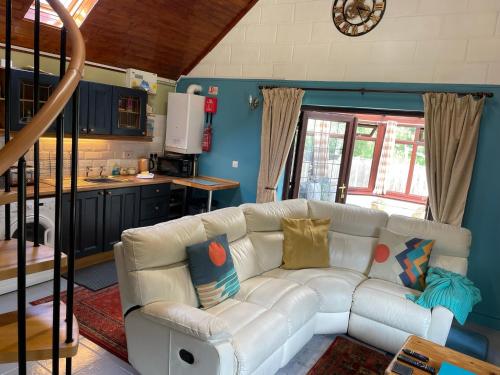 a living room with a white couch in a kitchen at The Annexe at Gomo in East Winch