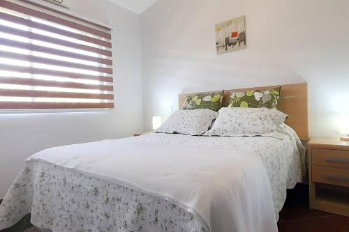 Schlafzimmer mit einem Bett mit weißer Bettwäsche und einem Fenster in der Unterkunft Jade Beach B apartamento 20 in Coco
