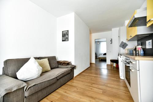 a living room with a couch and a kitchen at Ferienwohnung in der Sonnenstadt Lienz in Lienz
