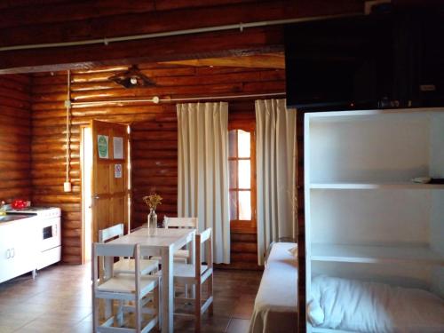 a room with a table and chairs and a bedroom at Monte Sion cabañas & relax in San Javier