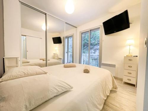 une chambre avec deux lits et un grand miroir dans l'établissement Cosy deux pièces, à Menton