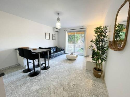 un salon avec une table et un canapé dans l'établissement Cosy deux pièces, à Menton