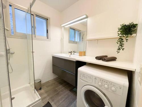 a bathroom with a washing machine and a sink at Cosy deux pièces in Menton