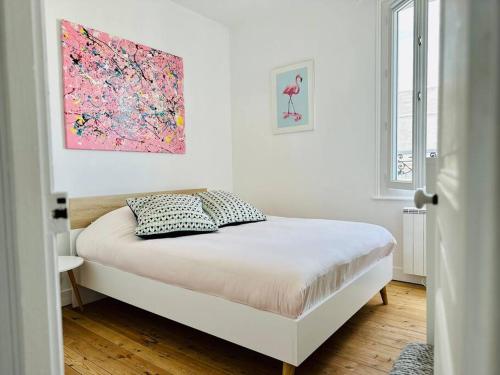 a bedroom with a bed with a painting on the wall at Bienvenue à la Maison Cayeux Beach in Cayeux-sur-Mer