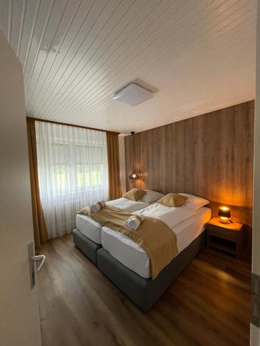 a bedroom with a large bed with a wooden wall at Ferienwohnung E in Soltau