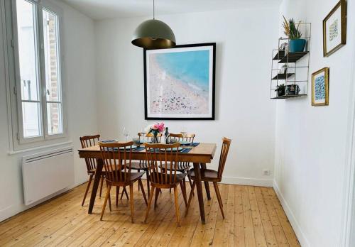 une salle à manger avec une table et des chaises en bois dans l'établissement Bienvenue à la Maison Cayeux Beach, à Cayeux-sur-Mer