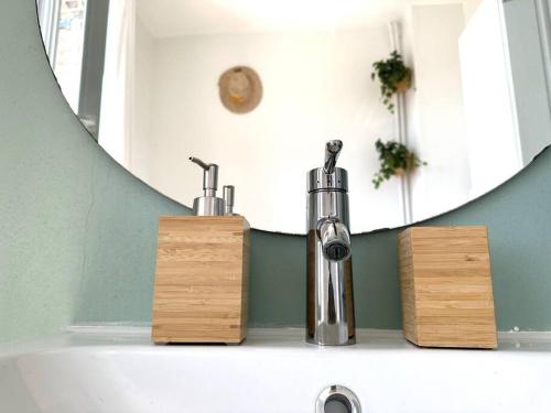 - un lavabo avec deux robinets et un miroir dans l'établissement Bienvenue à la Maison Cayeux Beach, à Cayeux-sur-Mer