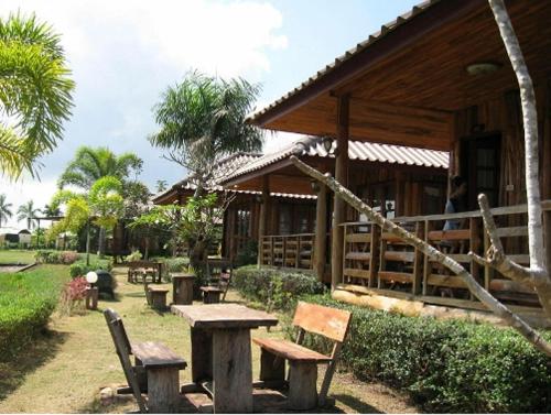 a building with a table and benches in front of it at Busai Country View in Wang Nam Khieo