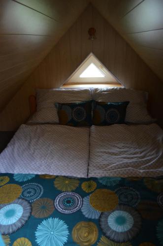 uma cama num pequeno quarto com uma janela em Chaloupka v Branne em Branná