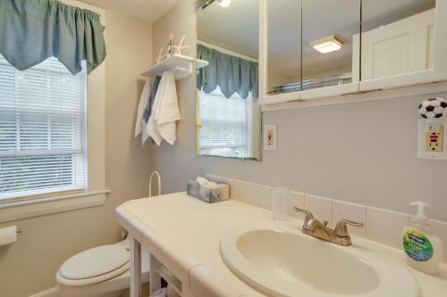 een badkamer met een wastafel, een toilet en een spiegel bij Hyannis Hideaway with Fireplace and Outdoor Dining in Hyannis
