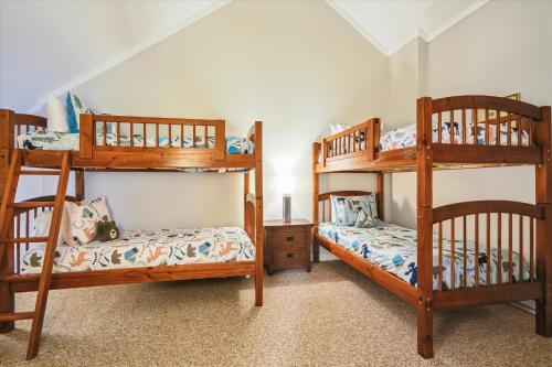 two bunk beds in a room with a bedroom at Perfect four bedroom condo with shuttle to the mountain, ski Back Whiffletree D8 in Killington