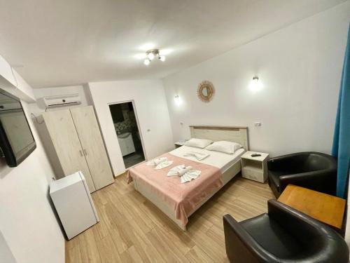 a hotel room with a bed and a chair at Vila Cochilia Costinesti in Costinesti