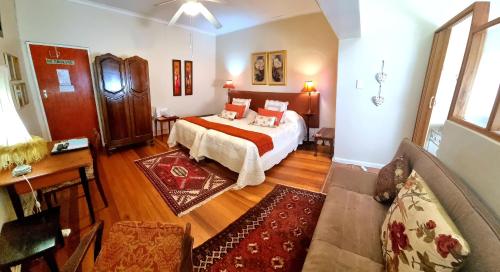 a bedroom with a bed and a couch in a room at Beau & I in Graaff-Reinet