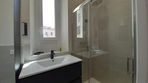 une salle de bain avec un lavabo et une douche en verre dans l'établissement Lovely apartment heart of Cannes, à Cannes
