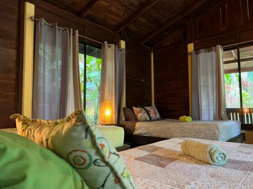 a bedroom with two beds and a window at Casita Lidia Bijagua in Bijagua