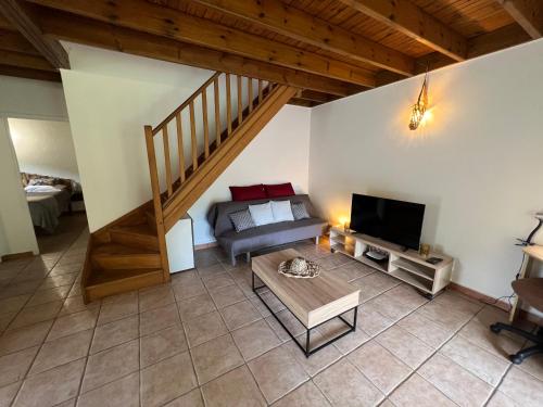 ein Wohnzimmer mit einem Sofa und einem TV in der Unterkunft Villa au calme avec Jacuzzi, Villa Le Boursoie in Les Abymes