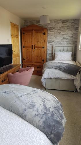a bedroom with two beds and a flat screen tv at Comfortable Family Home in Immingham in Immingham