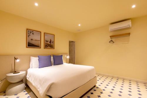 a bedroom with a large white bed with blue pillows at B Haus Hotel Boutique in Cartagena de Indias