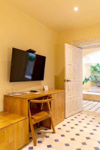 a room with a desk with a television on a wall at B Haus Hotel Boutique in Cartagena de Indias