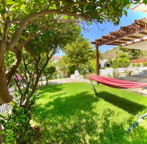 una hamaca a la sombra de un árbol en un patio en Villa Naya by the Beach, en Anavyssos