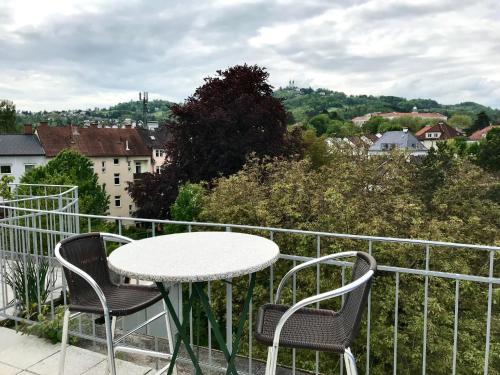 una mesa y sillas en un balcón con vistas en Stadtoase mit traumhaftem Ausblick, en Linz